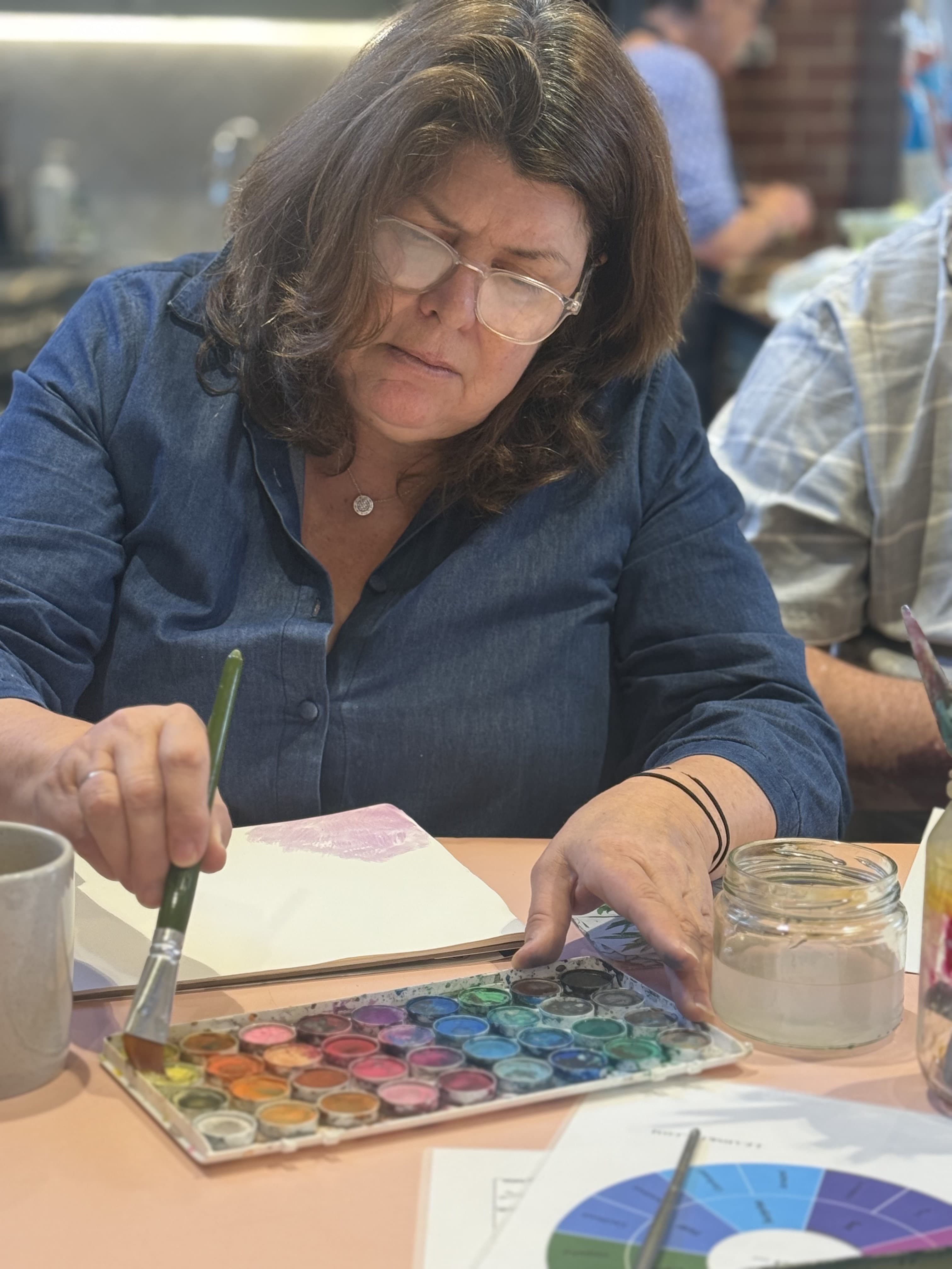 A Create and Connect participant choosing watercolours, studio session.