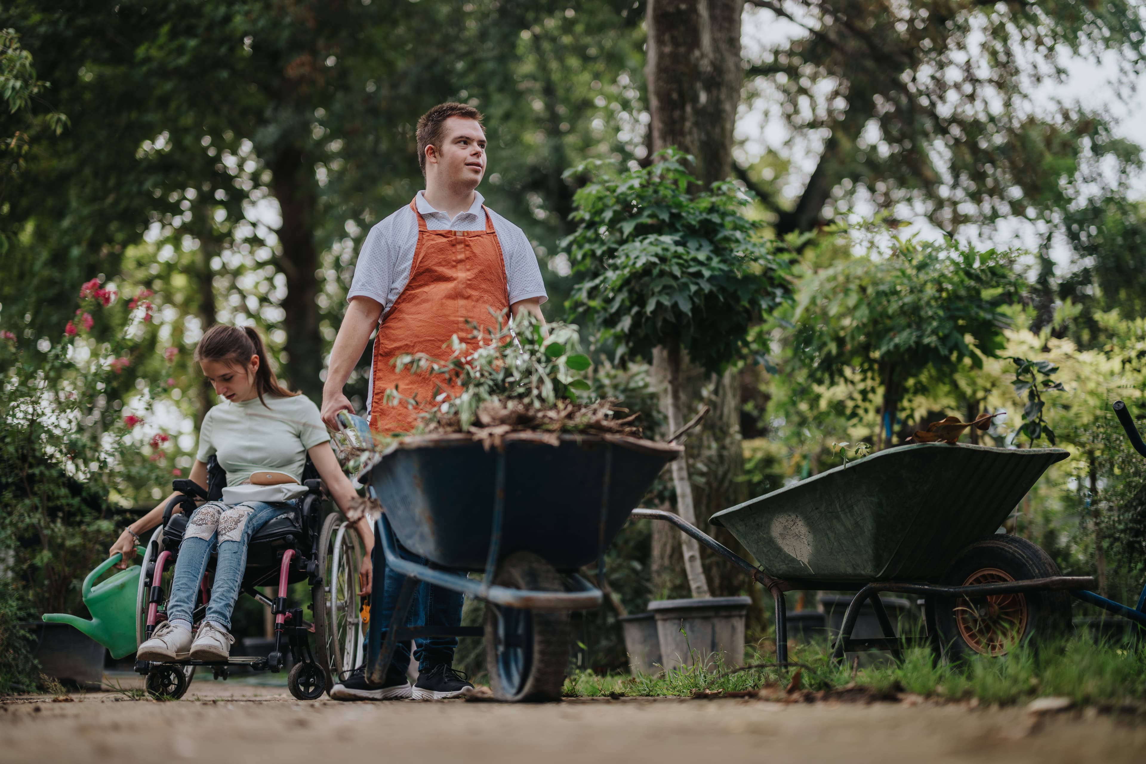 A Lyft Community participant in a wheelchair tending the garden alongside her support worker.